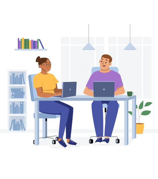 Two people working on laptops at a desk in a modern office.